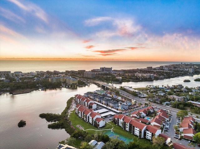 aerial view at dusk featuring a water view