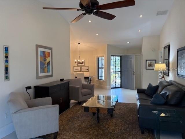 living room with ceiling fan with notable chandelier and high vaulted ceiling