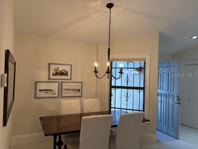 dining space featuring an inviting chandelier and lofted ceiling