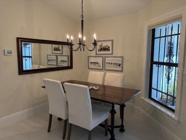 dining area with lofted ceiling and a chandelier