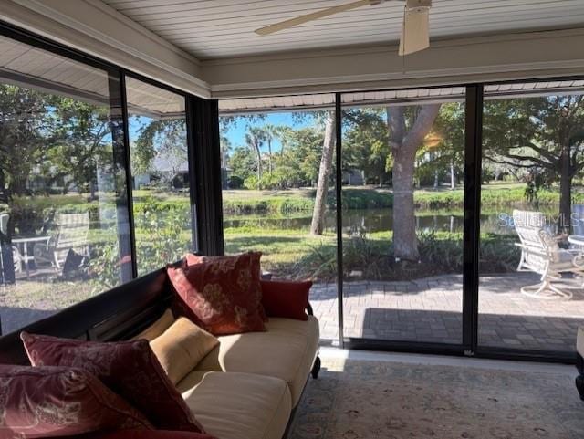 sunroom with a water view and ceiling fan