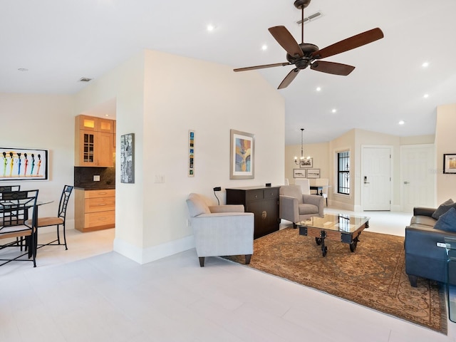 living room featuring ceiling fan with notable chandelier and vaulted ceiling