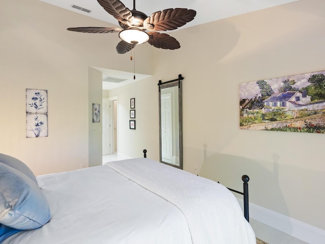 bedroom with a barn door and ceiling fan