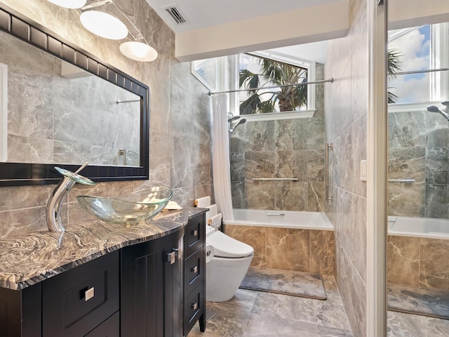 full bathroom featuring vanity, tile walls, shower / bathtub combination with curtain, and toilet