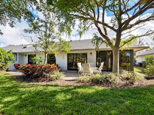 rear view of property with a yard and a patio area