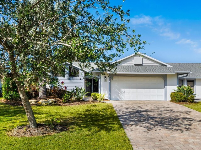 view of front of house with a garage and a front lawn