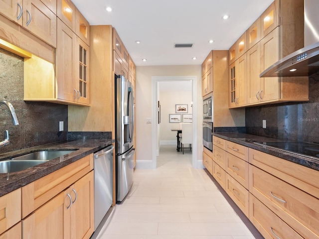 kitchen featuring wall chimney range hood, stainless steel appliances, sink, and light brown cabinets