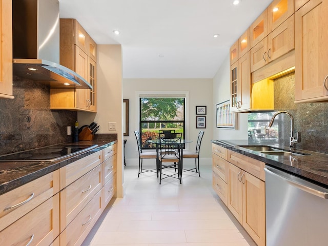 kitchen with wall chimney exhaust hood, sink, dark stone countertops, dishwasher, and black electric stovetop