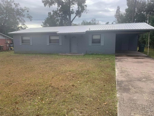 ranch-style home with a carport and a front lawn