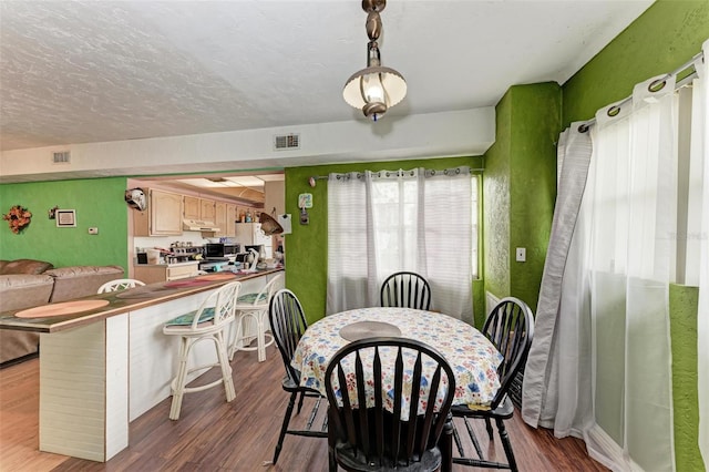 dining room featuring hardwood / wood-style floors and a textured ceiling