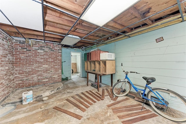 basement featuring wood walls and brick wall