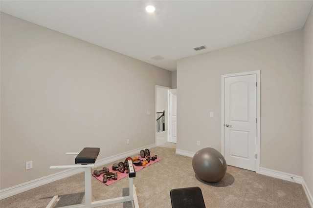 workout area featuring light carpet