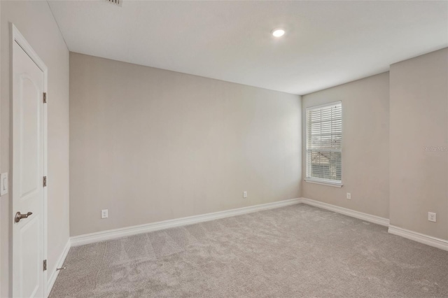 unfurnished room featuring light carpet