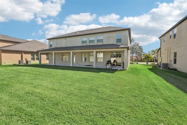 rear view of property with a yard, central AC, and a patio