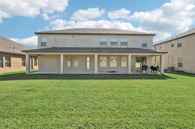 rear view of property featuring a patio, central air condition unit, and a lawn