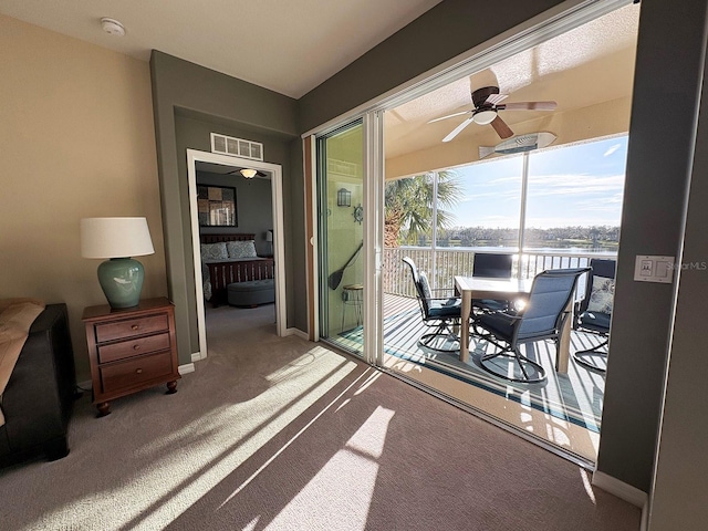 sunroom featuring a water view and ceiling fan