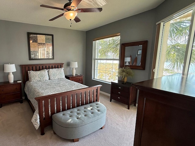 bedroom with ceiling fan, a textured ceiling, access to exterior, and light colored carpet