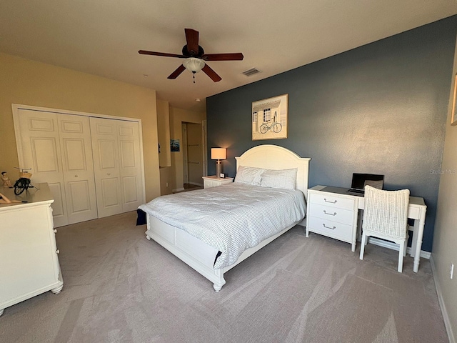 carpeted bedroom with ceiling fan and a closet