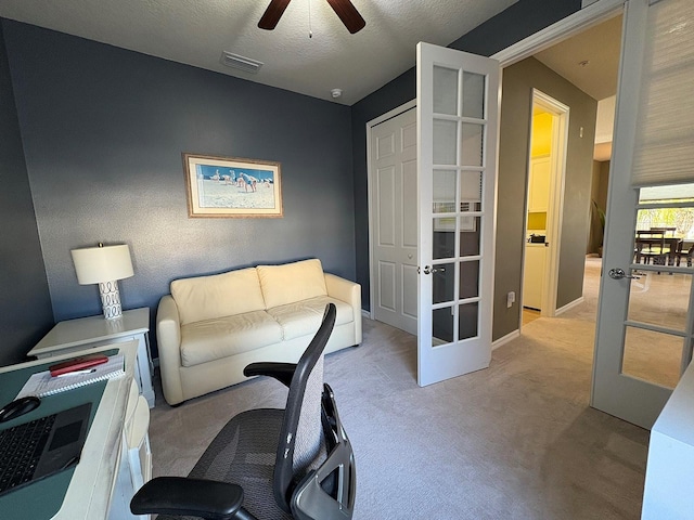 interior space featuring light carpet, french doors, ceiling fan, and a textured ceiling