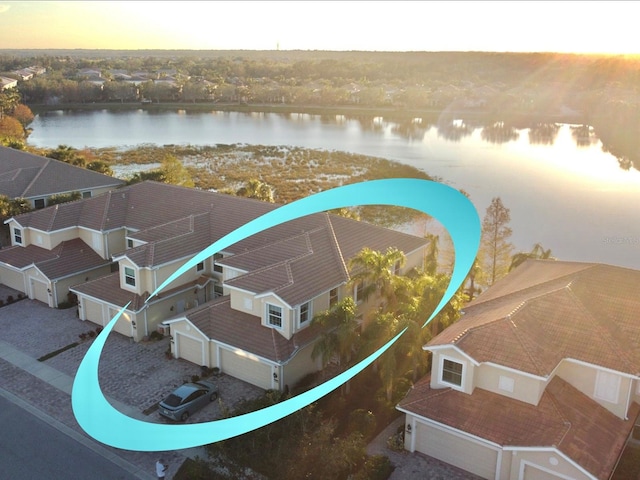 aerial view at dusk featuring a water view