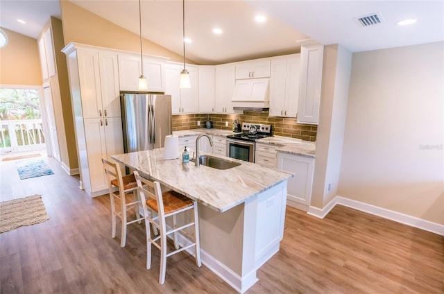 kitchen with white cabinetry, lofted ceiling, appliances with stainless steel finishes, and sink