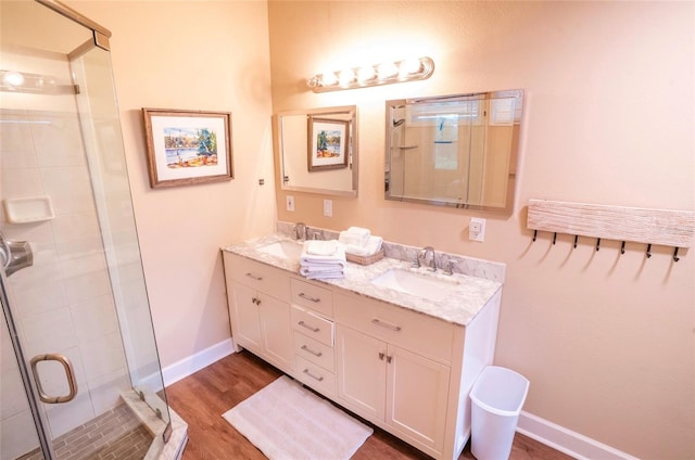 bathroom with hardwood / wood-style flooring, vanity, and walk in shower