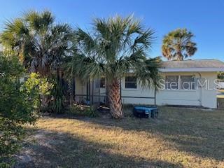 rear view of property featuring a lawn