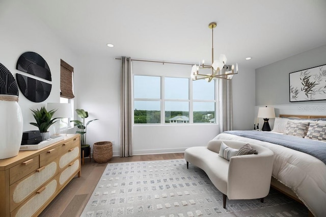 bedroom with light hardwood / wood-style floors and a notable chandelier