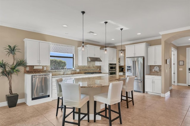 kitchen featuring white cabinetry, appliances with stainless steel finishes, a center island, and tasteful backsplash