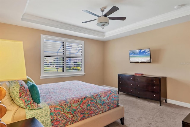 carpeted bedroom with crown molding, ceiling fan, and a tray ceiling