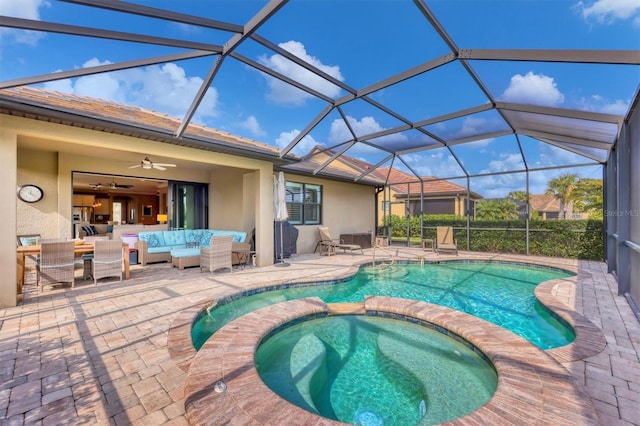 view of swimming pool featuring outdoor lounge area, an in ground hot tub, a lanai, ceiling fan, and a patio area