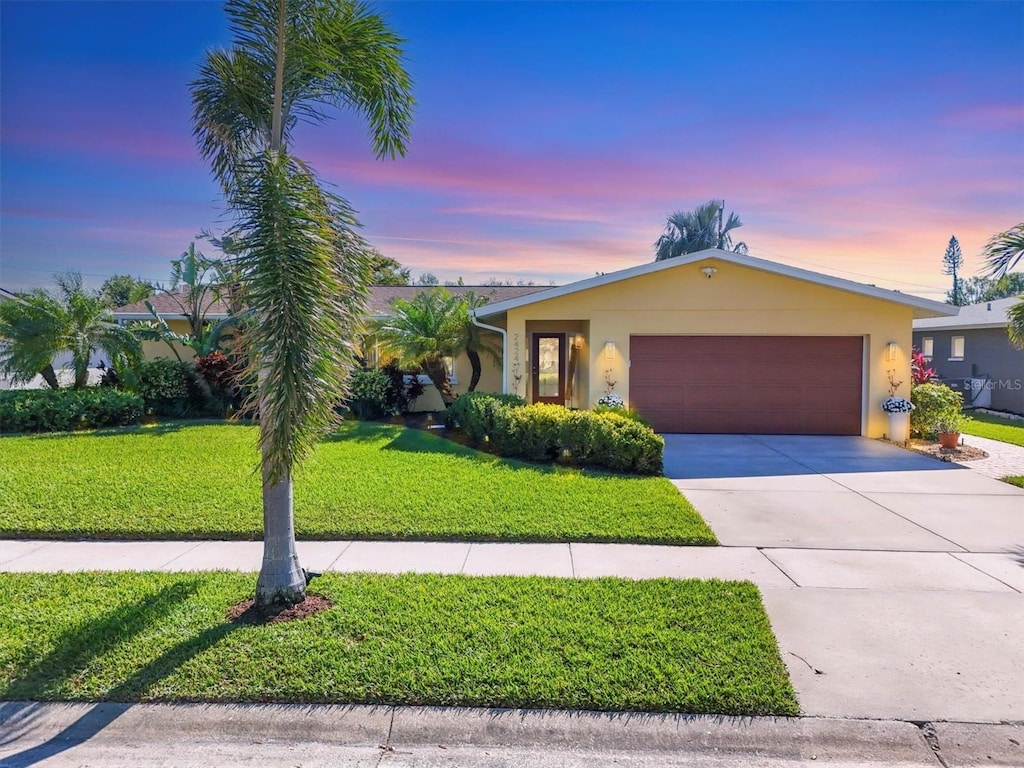 view of front of property with a garage and a yard