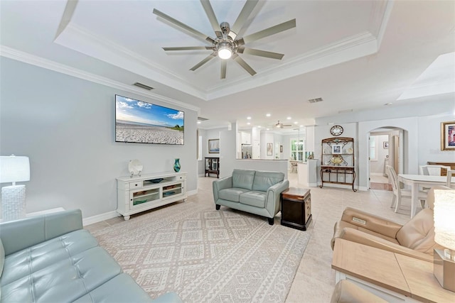 tiled living room featuring ornamental molding, ceiling fan, and a tray ceiling