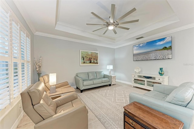 living room with crown molding, ceiling fan, and a tray ceiling