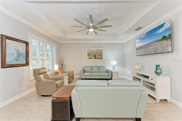 living room with crown molding, light tile patterned floors, a tray ceiling, and ceiling fan