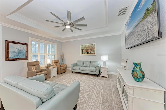 living room featuring a raised ceiling, ornamental molding, and ceiling fan