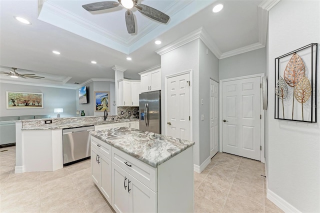 kitchen with crown molding, white cabinetry, stainless steel appliances, a center island, and kitchen peninsula