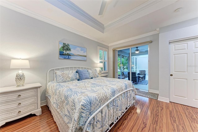 bedroom featuring crown molding, a tray ceiling, ceiling fan, access to exterior, and hardwood / wood-style floors