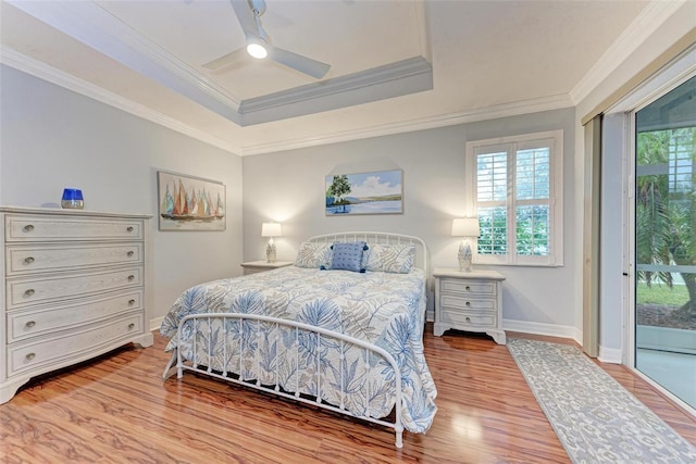 bedroom with hardwood / wood-style flooring, ornamental molding, access to exterior, ceiling fan, and a raised ceiling