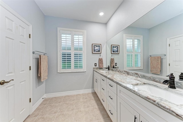 bathroom with tile patterned floors, vanity, and a wealth of natural light