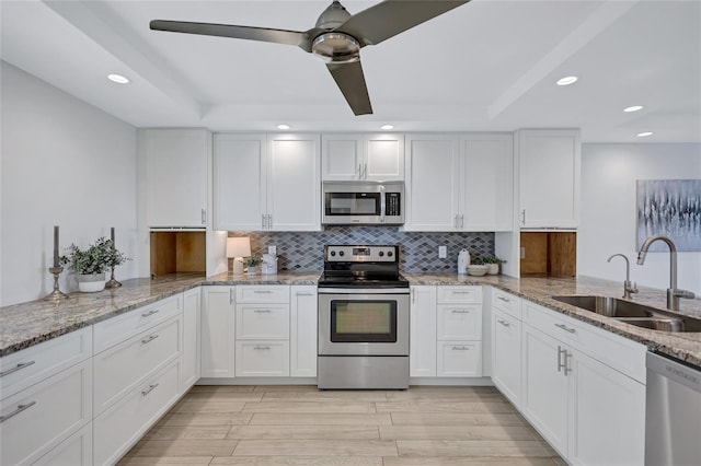 kitchen featuring appliances with stainless steel finishes, sink, decorative backsplash, and white cabinets