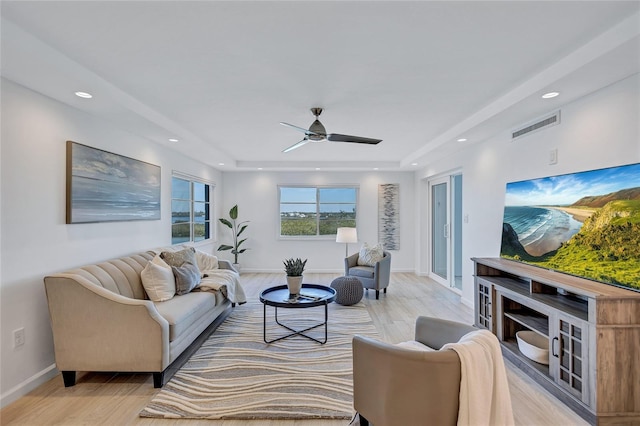 living room with ceiling fan and light hardwood / wood-style flooring