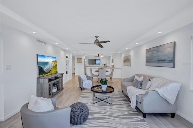 living room featuring ceiling fan and light hardwood / wood-style floors