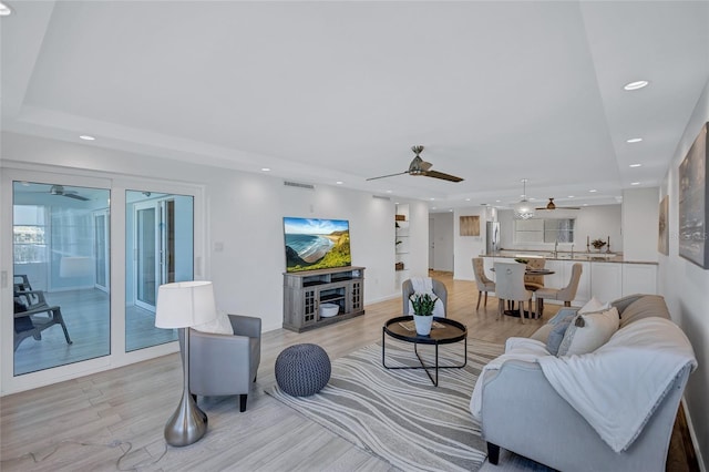 living room featuring ceiling fan and light wood-type flooring