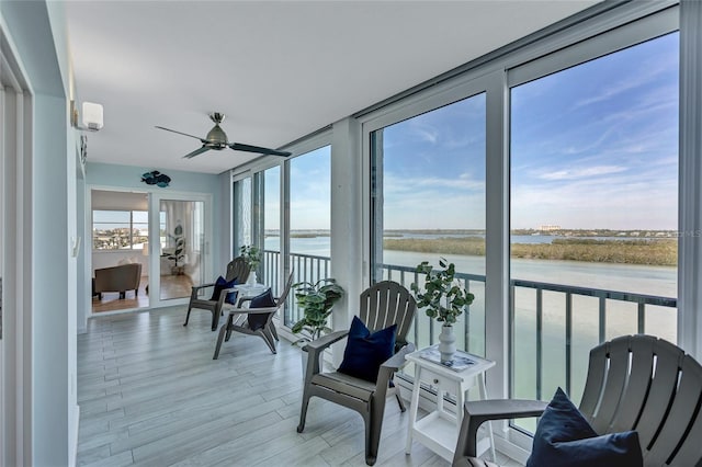 sunroom / solarium featuring a water view and ceiling fan