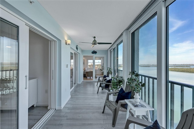 interior space with a water view and ceiling fan