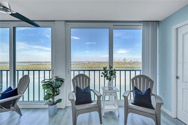 sunroom featuring a water view