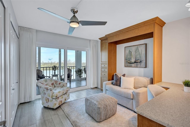 living room featuring hardwood / wood-style floors, ceiling fan, and a water view