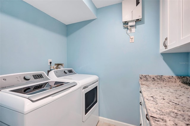 laundry room with cabinets, separate washer and dryer, and water heater