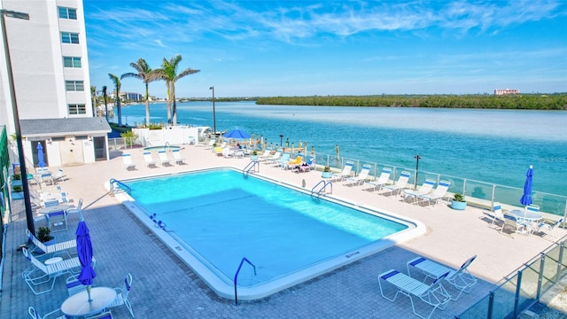 view of pool with a water view and a patio area